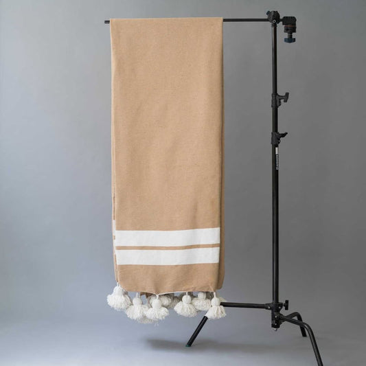 Manta beige con rayas y pompones blancos
