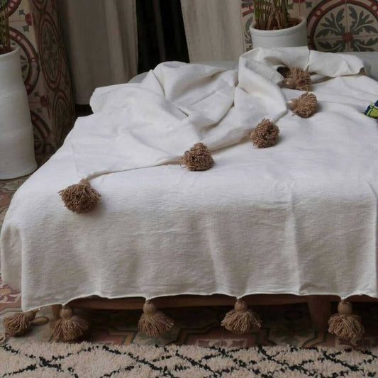 Manta blanca con pompones beige
